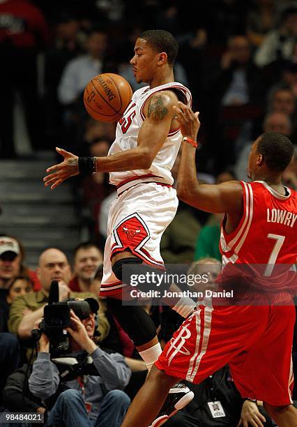 Derrick Rose of the Chicago Bulls tries to control the ball past Kyle Lowery of the Houston Rockets at the United Center on March 22, 2010 in...