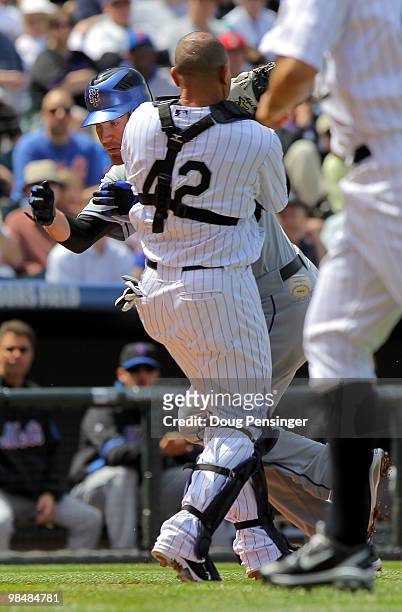 Starting pitcher Mike Pelfrey of the New York Mets gets past catcher Miguel Olivo of the Colorado Rockies to score on a fielder's choice grounder by...