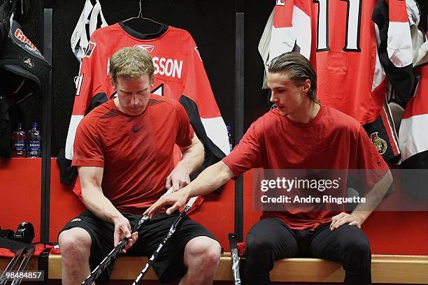 Daniel Alfredsson and Erik Karlsson of the Ottawa Senators talk in the locker room prior to a game against the Buffalo Sabres at Scotiabank Place on...