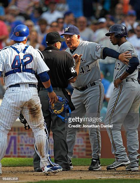 Manager Ken Macha of the Milwaukee Brewers, wearing a number 42 jersey in honor of Jackie Robinson, holds back player Alcides Escobar as he argues...