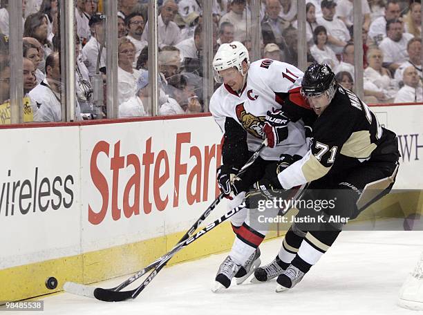 Daniel Alfredsson of the Ottawa Senators and Evgeni Malkin of the Pittsburgh Penguins battle for a loose puck in Game One of the Eastern Conference...