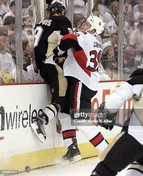 Matt Carkner of the Ottawa Senators checks Pascal Dupuis of the Pittsburgh Penguins in Game One of the Eastern Conference Quarterfinals during the...