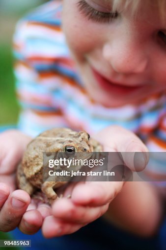 Boy holding a frog in his hands