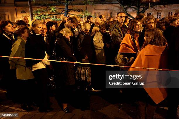 Mourners, some of who had been standing in line for at least 14 hours, wait to pay their last respects at the coffins of late Polish President Lech...