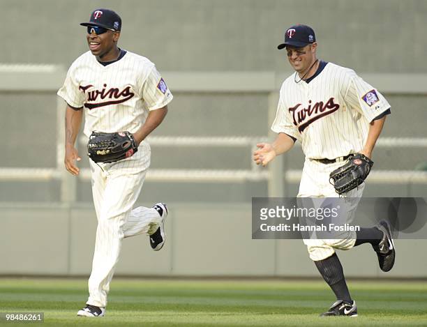 Delmon Young and Michael Cuddyer of the Minnesota Twins celebrate a Twins win against the Boston Red Sox during the Twins home opener at Target Field...