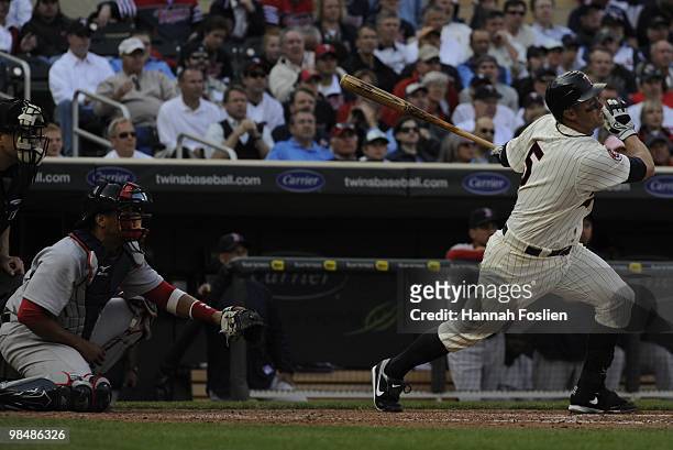 Michael Cuddyer of the Minnesota Twins bats as Victor Martinez of the Boston Red Sox catches in the sixth inning during the Twins home opener at...