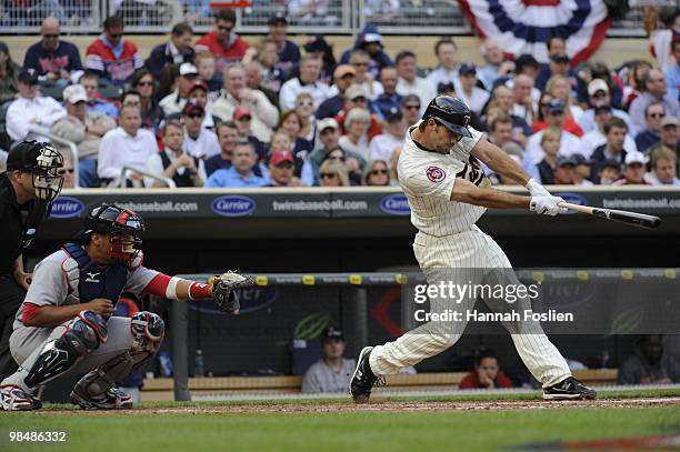 Hardy of the Minnesota Twins bats as Victor Martinez of the Boston Red Sox catches in the fifth inning during the Twins home opener at Target Field...