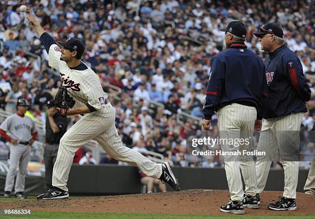 Carl Pavano of the Minnesota Twins throws a practice pitch after being hit in the hand by a ball as pitching coach Rick Anderson and manager Ron...