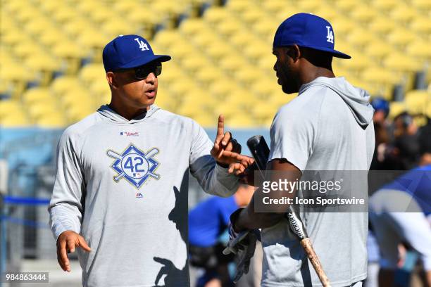 Los Angeles Dodgers manager Dave Roberts talks with right fielder Yasiel Puig during batting practice before a MLB game between the Chicago Cubs and...