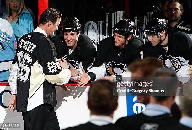 Mario Lemieux of the Pittsburgh Penguins shakes hands with Brooks Orpik and Mark Eaton during a pregame alumni ceremony before the final regualr...