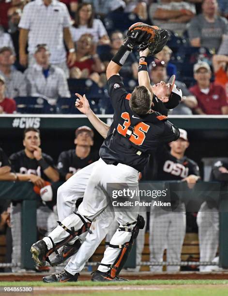 Infielder Michael Gretler of the Oregon State Beavers and catcher Adley Rutschman collide attempting to catch a foul ball in the ninth inning against...