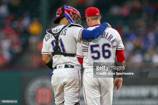 With the bases loaded, Texas Rangers Catcher Robinson Chirinos visits the mound to talk with Pitcher Austin Bibens-Dirkx during the game between the...