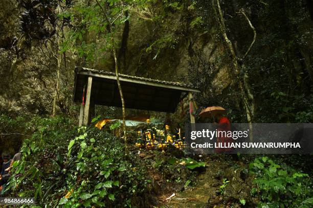 Buddhist monk prays at a small temple near the entrance of the Tham Luang cave at the Khun Nam Nang Non Forest Park in Chiang Rai on June 27, 2018...