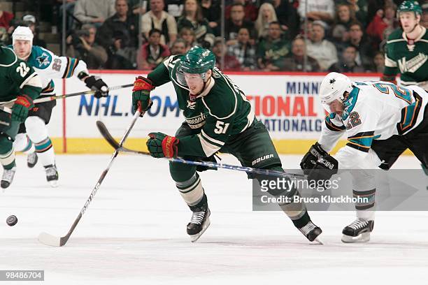 James Sheppard of the Minnesota Wild and Dan Boyle of the San Jose Sharks skate to the puck during the game at the Xcel Energy Center on April 2,...