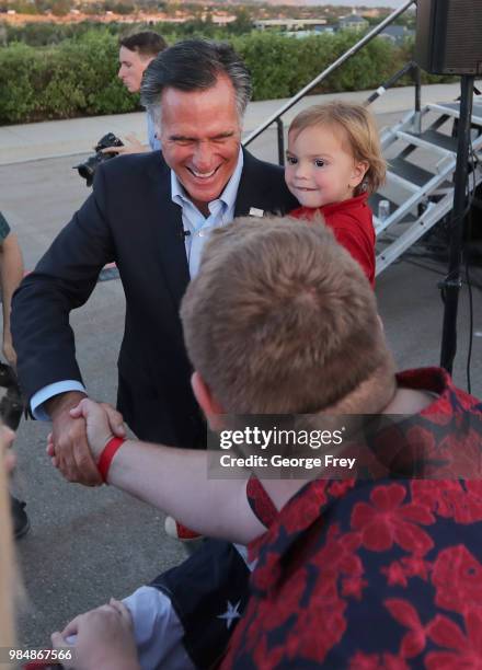 Mitt Romney and his grandson Dane Romney shakes hands with supporters at his victory rally on June 26, 2018 in Orem, Utah. Romney was declared the...