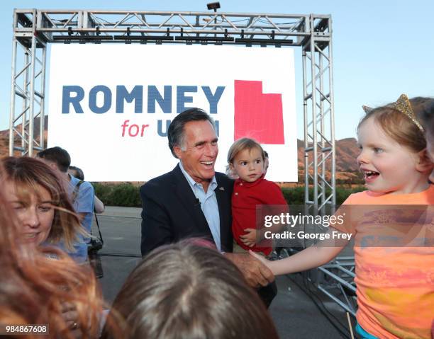 Mitt Romney and his grandson Dane Romney greets supporters after his victory rally on June 26, 2018 in Orem, Utah. Romney was declared the winner...