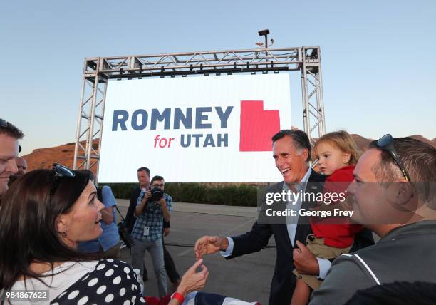 Mitt Romney and his grandson Dane Romney greets supporters after his victory rally on June 26, 2018 in Orem, Utah. Romney was declared the winner...