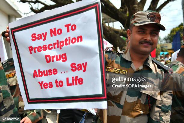 Member of Indian Paramilitary Force holding posters during the rally. Member of Indian Paramilitary Force and Indian Police are walking and riding...