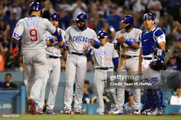 Jason Heyward, Addison Russell, and Ben Zobrist of the Chicago Cubs greet Javier Baez of the Chicago Cubs at home plate after his grandslam while...