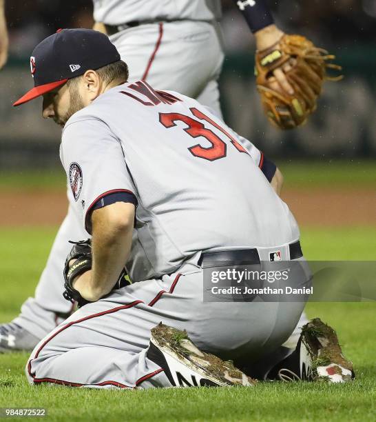 Starting pitcher Lance Lynn of the Minnesota Twins reacts after slipping on the wet greass trying to grab a ball against the Chicago White Sox at...