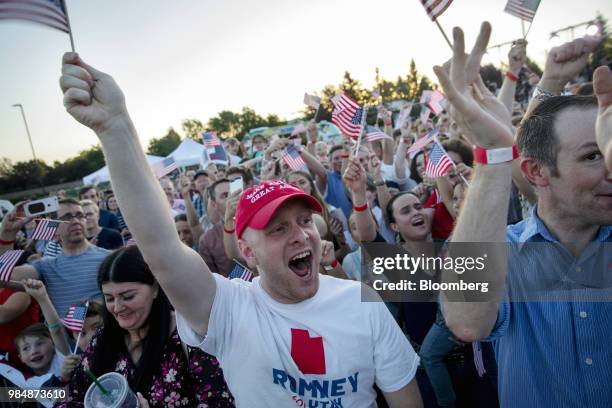 Attendees cheer and wave flags during an election night rally for Mitt Romney, Republican U.S Senate candidate, in Provo, Utah, U.S., on Tuesday,...