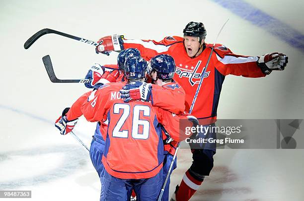 Joe Corvo of the Washington Capitals celebrates with Jason Chimera and other teammates after scoring in the first period against the Montreal...