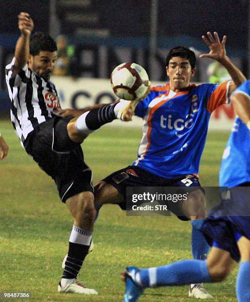 Victor Hugo Ayala of Paraguayan Libertad vies for the ball with Jorge Gonzalez of Bolivian Blooming on April 15 during a Libertadores Cup football...