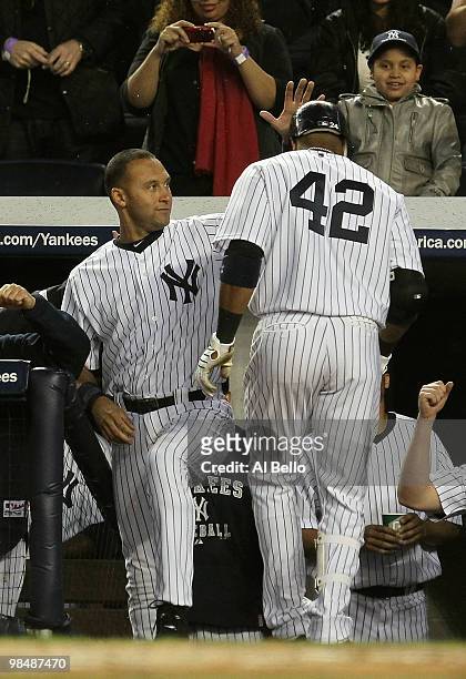 Robinson Cano of the New York Yankees is met by Derek Jeter after hitting a home run against the Los Angeles Angels of Anaheim during their game on...