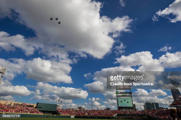Three F18 fighter jets fly over TD Ameritrade Park before the first game between Arkansas and Oregon State of the College World Series finals in...