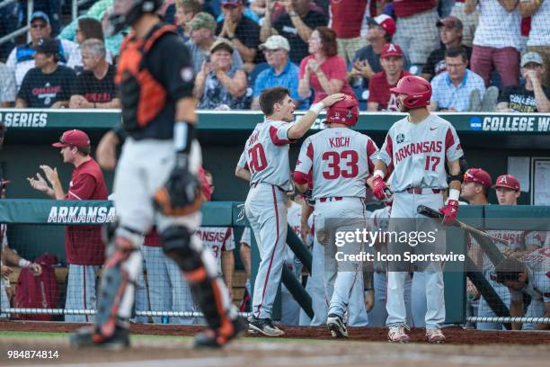Arkansas's Grant Koch scores in the fifth while Arkansas's Carson Shaddy pats him on the hat congratulating him in the fifth against Oregon State...