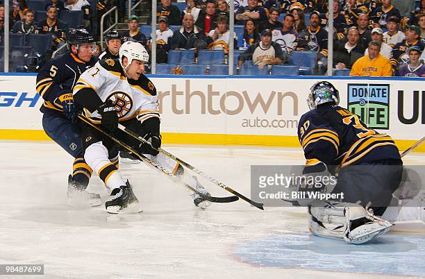 Ryan Miller and Toni Lydman of the Buffalo Sabres stop Milan Lucic of the Boston Bruins in Game One of the Eastern Conference Quarterfinals during...