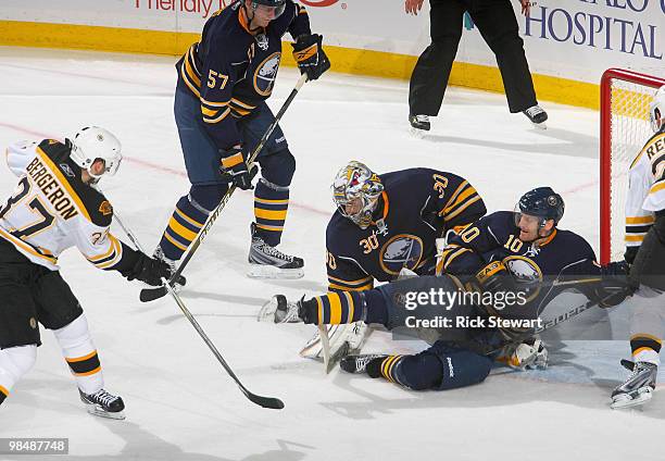 Tyler Myers, Ryan Miller and Henrik Tallinder of the Buffalo Sabres defend on a shot by Patrice Bergeron of the Boston Bruins in Game One of the...