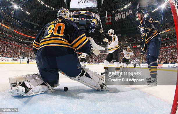 Ryan Miller and Tyler Myers of the Buffalo Sabres watch as the Boston Bruins celebrate a second-period goal scored by Mark Recchi in Game One of the...