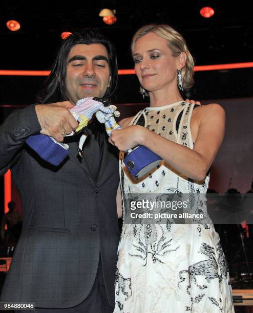 Film director Fatih Akin and actress Diane Kruger stand next to each holding their trophies in their hands after the award ceremony of the Bavarian...