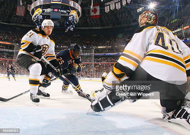 Michael Grier of the Buffalo Sabres fights for a rebound against Andrew Ference and Tuukka Rask of the Boston Bruins in Game One of the Eastern...