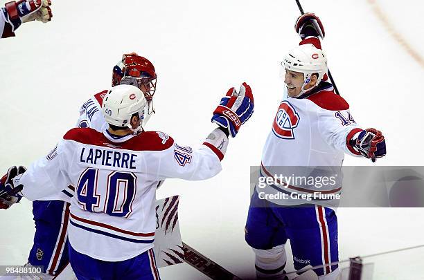 Tomas Plekanec of the Montreal Canadiens celebrates with Jaroslav Halak and Maxim Lapierre after scoring the game-winning goal in overtime against...