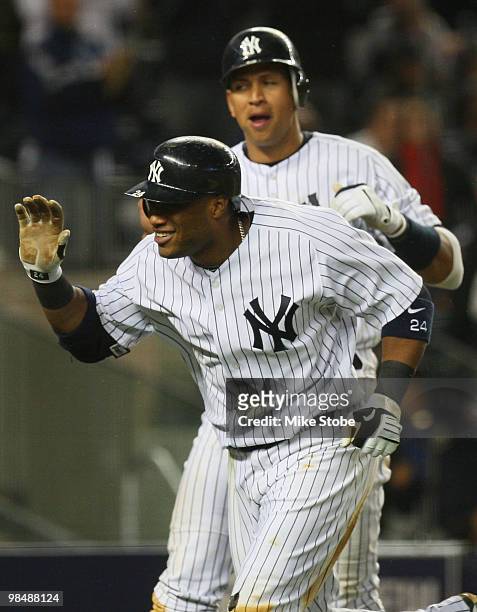 Robinson Cano of the New York Yankees is greeted at home plate by Alex Rodriguez after hitting his second homerun of the game in the bottom of the...