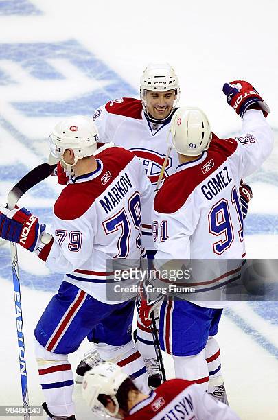 Tomas Plekanec of the Montreal Canadiens celebrates with Scott Gomez and Andrei Markov after scoring the game-winning goal in overtime against the...