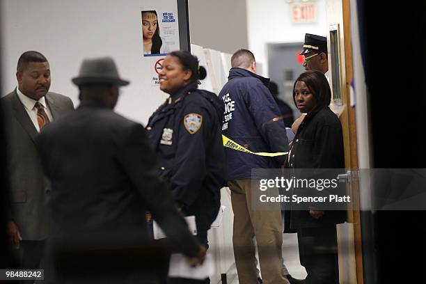 New York City Police Officers stand inside the building where a New York state parole officer was shot on April 15, 2010 in the Brooklyn borough of...
