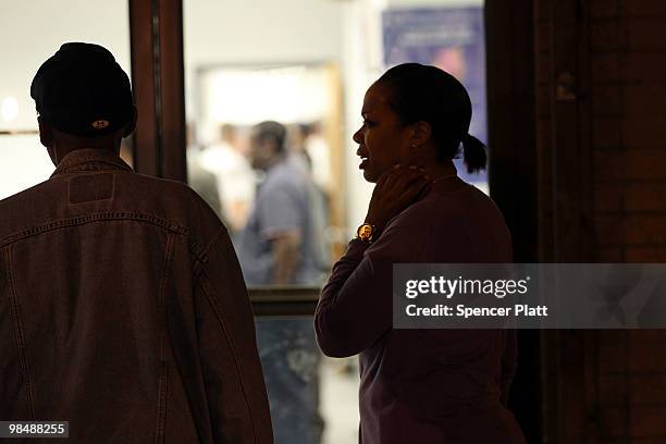 People stand outside the building where a New York state parole officer was shot on April 15, 2010 in the Brooklyn borough of New York City. The...