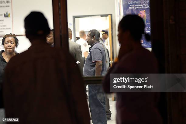 People stand outside the building where a New York state parole officer was shot on April 15, 2010 in the Brooklyn borough of New York City. The...