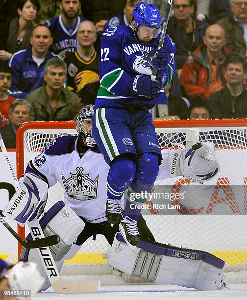 Goalie Jonathan Quick of the Los Angeles Kings reaches out to make a glove save while Daniel Sedin of the Vancouver Canucks tries to get out of the...