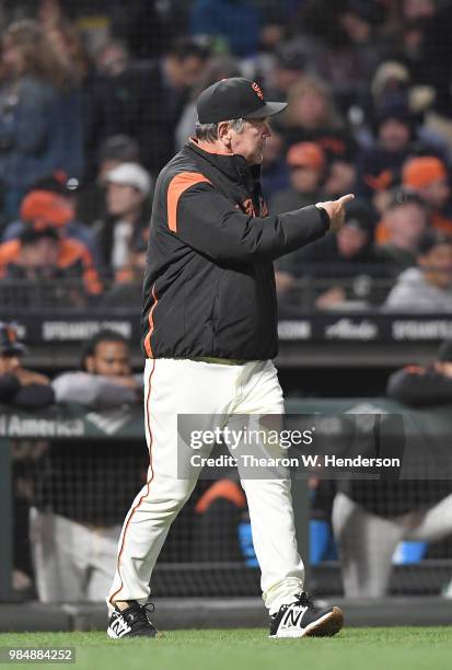 Manager Bruce Bochy of the San Francisco Giants signals the bullpen to make a pitching change against the Colorado Rockies in the top of the seventh...