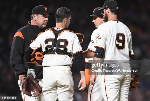 Manager Bruce Bochy of the San Francisco Giants takes the ball from starting pitcher Derek Holland taking Holland out of the game against the...