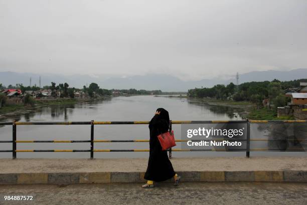 Woman can be seen walking over a Bridge in Sopore town of District Baramulla, Jammu and Kashmir, India, on 27 June 2018.