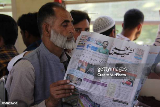 Passenger reads newspaper in Baramulla-Banihal bound Train in Jammu &amp; Kashmir, India, on 27 June 2018.