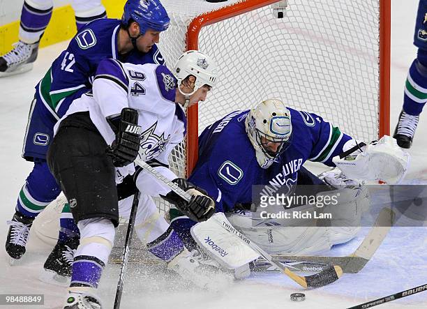 Goalie Roberto Luongo of the Vancouver Canucks stops Ryan Smyth of the Los Angeles Kings as Kyle Wellwood of the Canucks tries to help stop Smyth on...