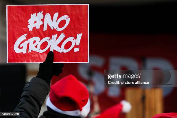 Member of Juso holding a sign with the text "#NoGroko!" at a demonstration in front of the WCCB during the SPD's extraordinary party convention in...
