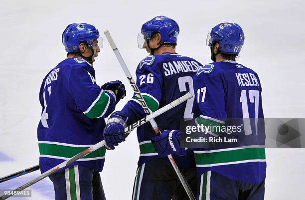 Mikael Samuelsson of the Vancouver Canucks is congratulated by teammate Alex Burrows and Ryan Kesler after scoring the game-winning goal against the...