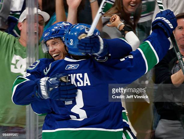 Mikael Samuelsson of the Vancouver Canucks is congratulated by teammate Kevin Bieksa after scoring the overtime winning goal in Game One of the...